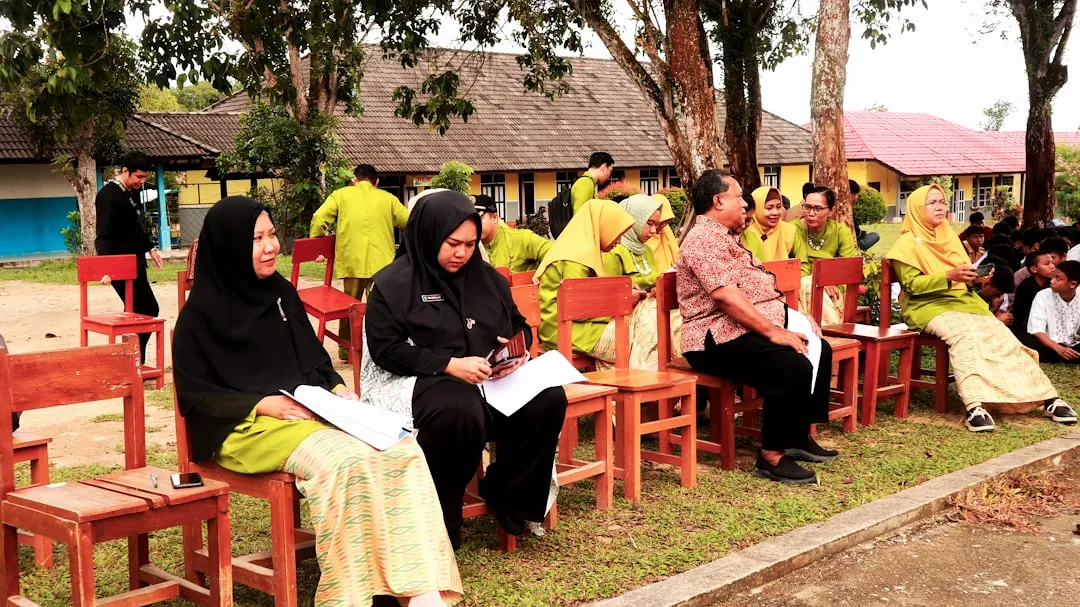 A group of people sitting on top of wooden chairs