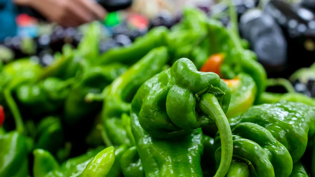 a pile of green peppers sitting on top of a table