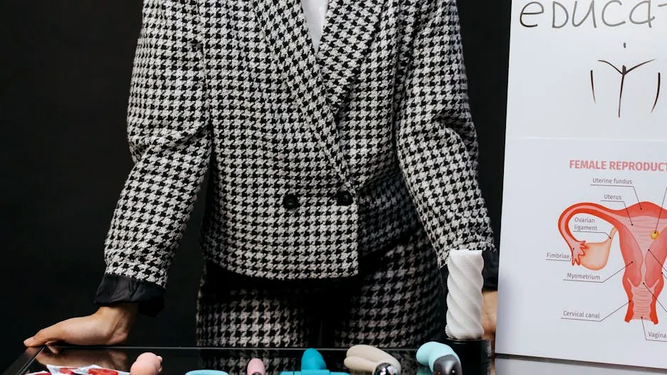 A visual setup for sex education featuring a variety of sex toys and educational materials on a glass table.