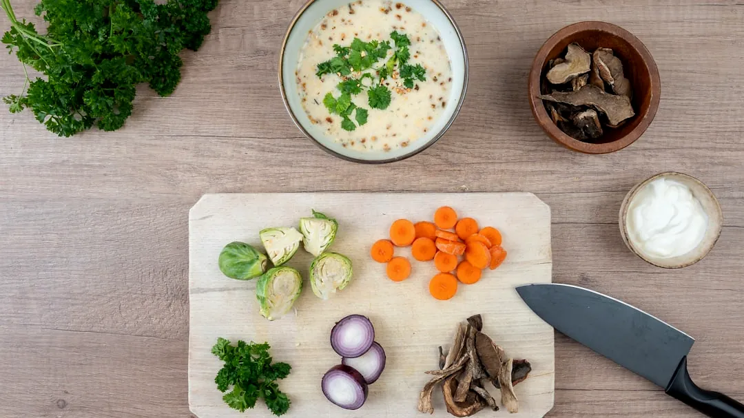 Chopped vegetables and ingredients for cooking on cutting board.