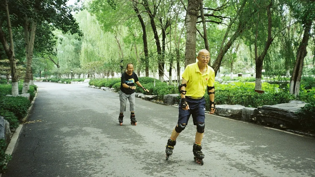 Two people are rollerblading on a pathway.