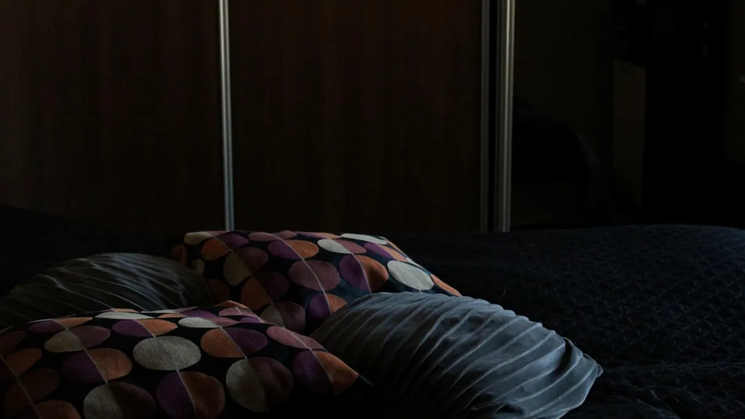 a bed with a black comforter and two pillows