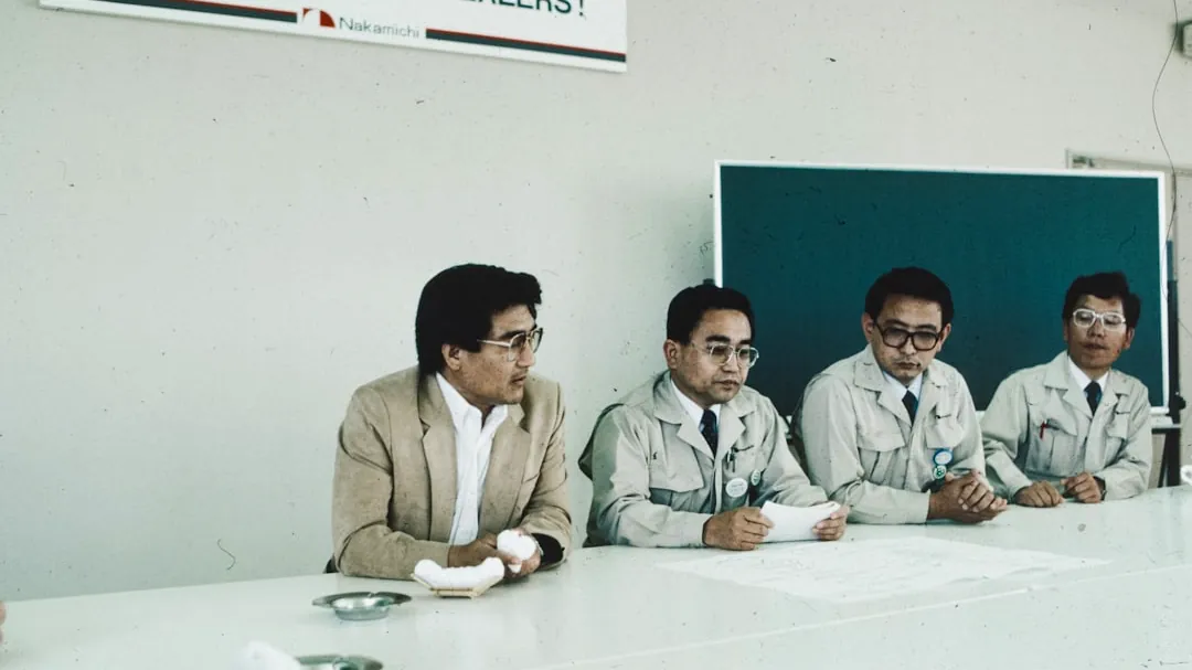 A group of men sitting around a white table
