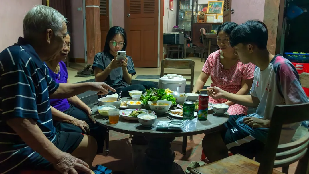 a group of people sitting around a table eating food