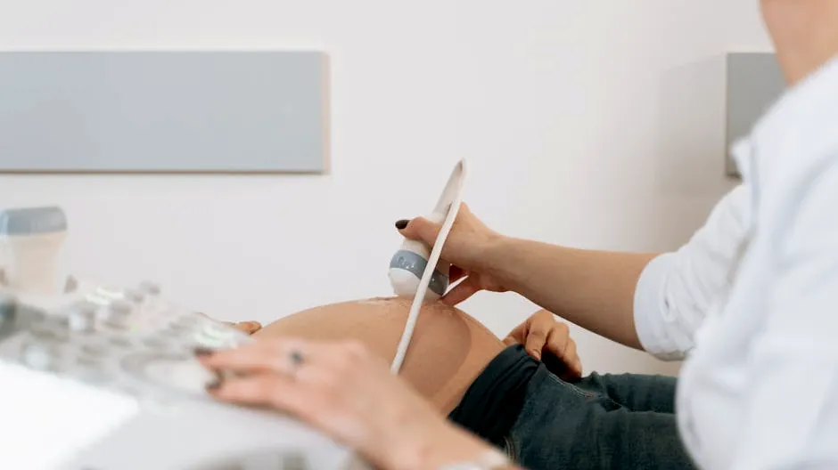A healthcare professional performs an ultrasound on a pregnant woman in a clinic.