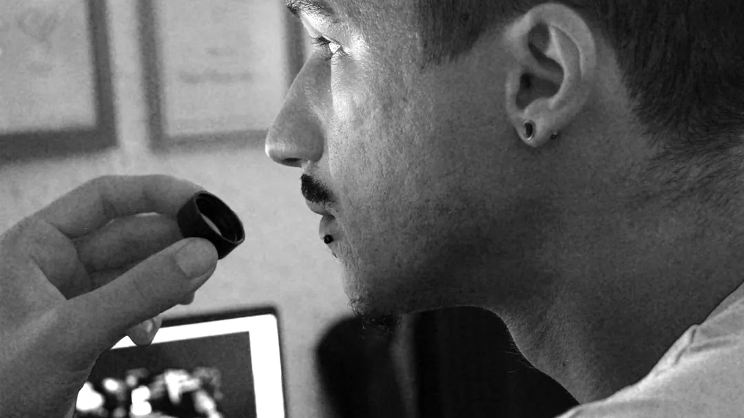 a man holding a pen and looking at a computer screen