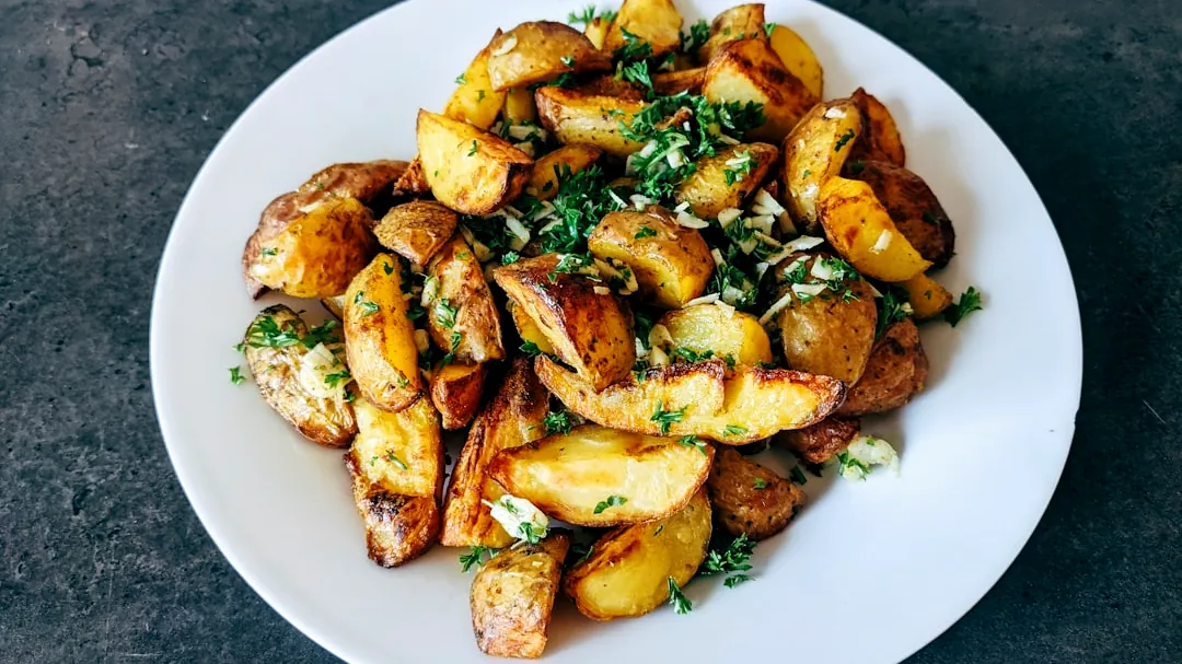a white plate topped with potatoes and parsley
