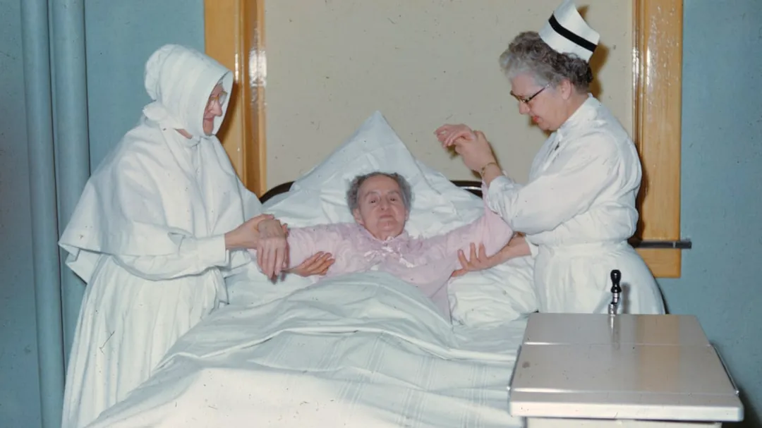 a woman in a hospital bed being assisted by a nurse