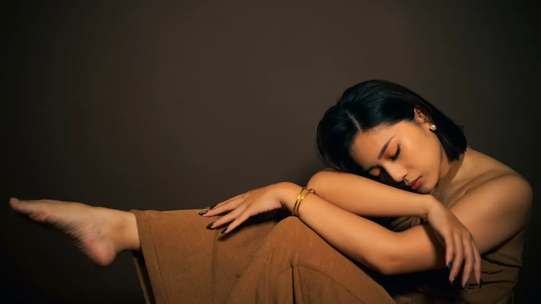 a woman sitting on the ground with her arms crossed