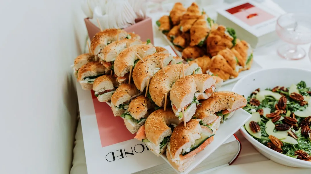 Assortment of bagels, croissants, and salad on a table