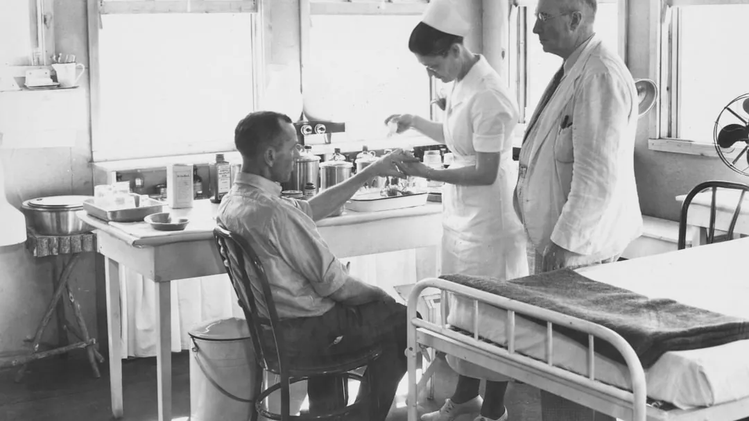 Nurse attends to patient with doctor observing