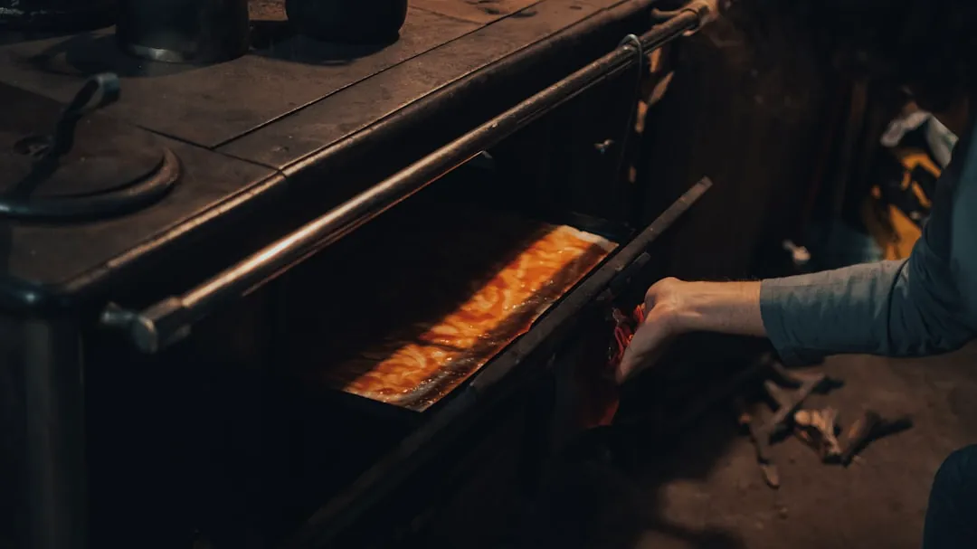 person in gray long sleeve shirt holding brown wooden stick