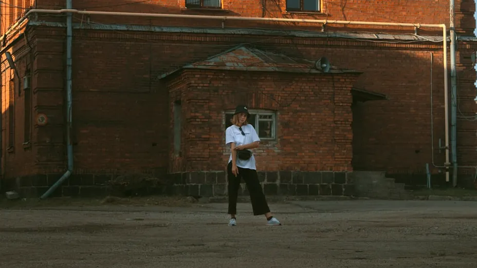 person on white top by bricked building