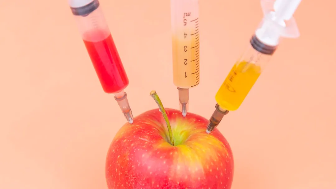 red apple beside clear glass bottle