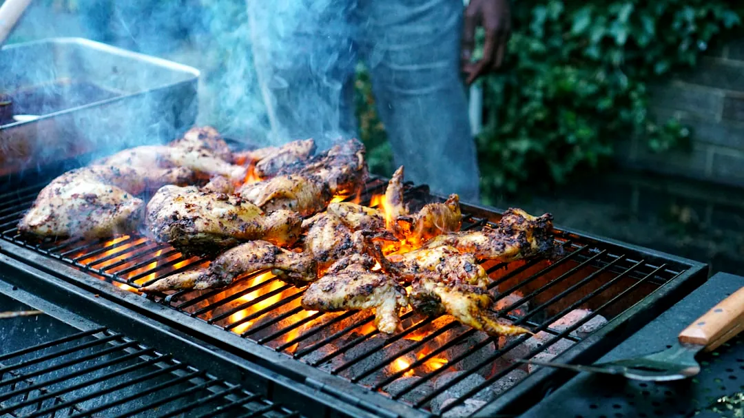 unknown person grilling chicken meat outdoors