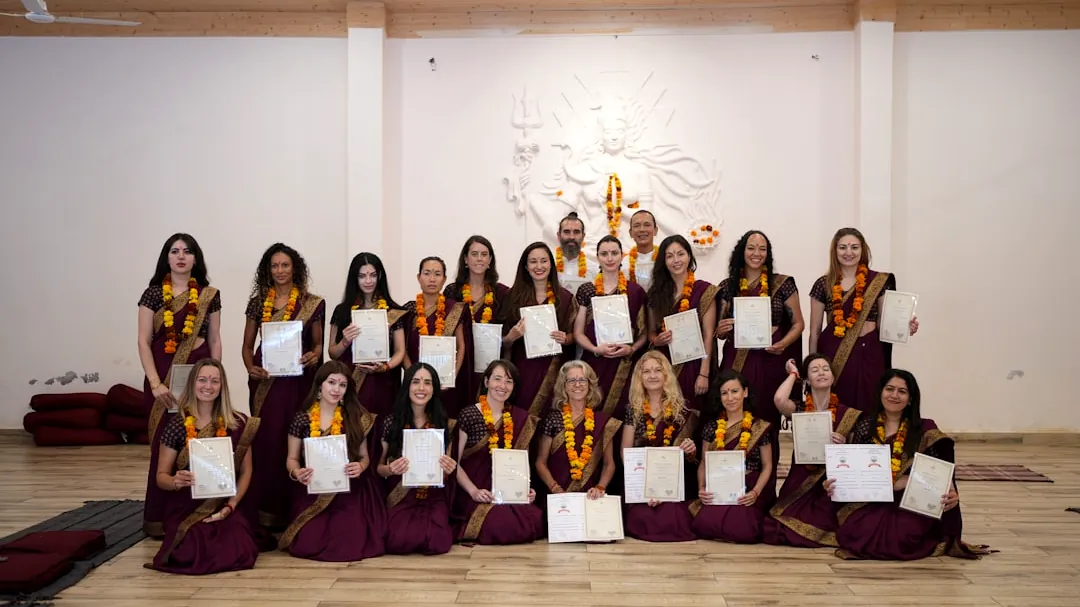Group of women holding certificates in a yoga studio.