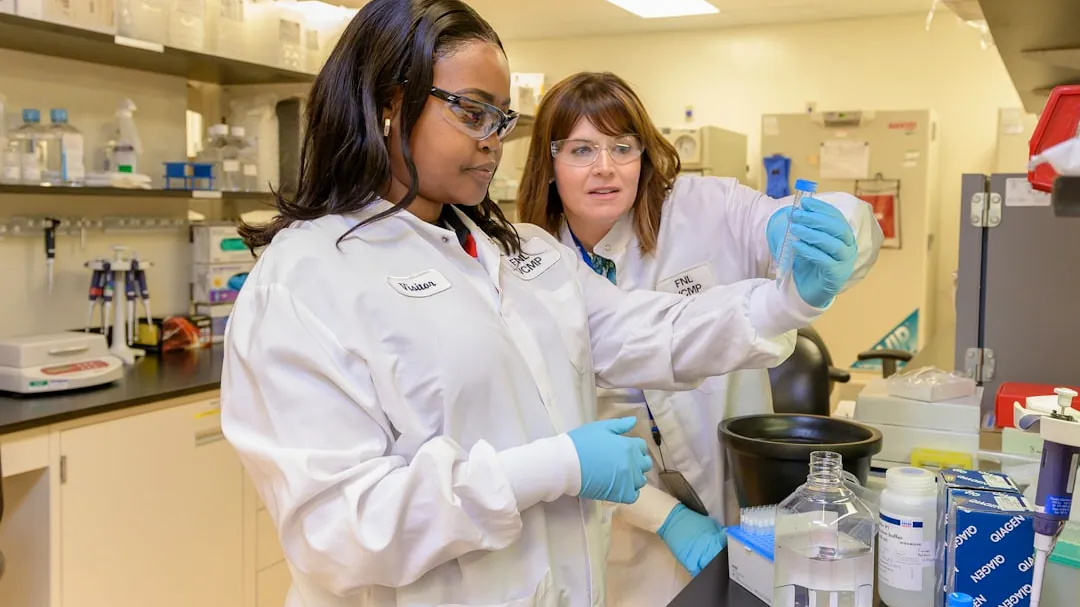 two women in lab coats working in a lab